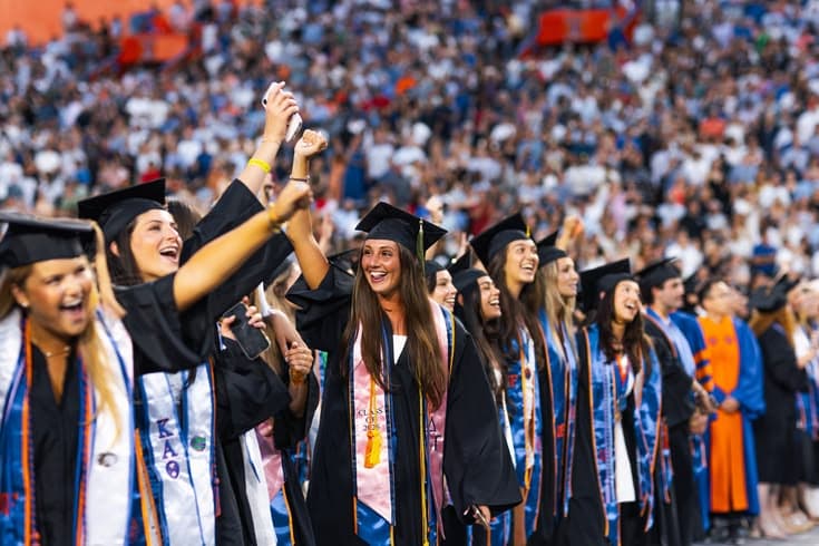 Étudiantes en tenue de remise de diplômes réunies lors d’une cérémonie